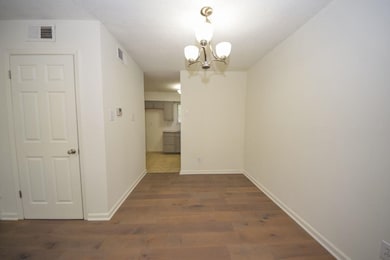 Unfurnished dining area featuring a chandelier and wood finished floors