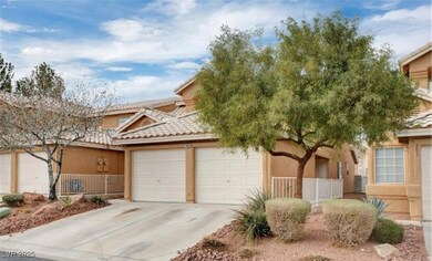 View of front facade with a tiled roof, a garage,