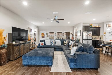 Living room with light wood-style floors, recessed lighting, and a ceiling fan