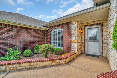 Doorway to property featuring brick siding and roof with shingles