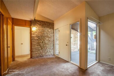 View of entry showcasing rock wall.  Open doorway 