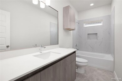 Full bath featuring washtub / shower combination, vanity, and light tile patterned floors