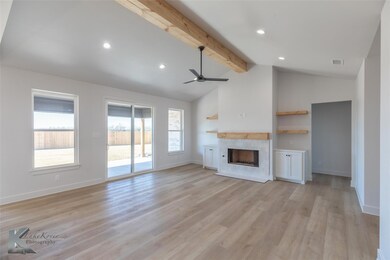Unfurnished living room with a tile fireplace, vau