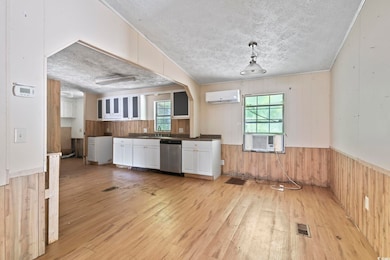 Kitchen featuring wood walls, a wall unit AC, ligh