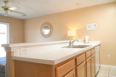 Kitchen featuring ceiling fan, light countertops, 