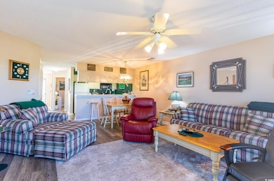Living room featuring ceiling fan, hardwood / wood