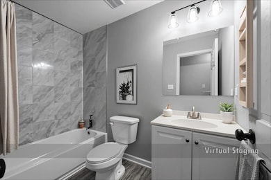 Full bathroom featuring shower / bathtub combination with curtain, vanity, and dark wood-style floors