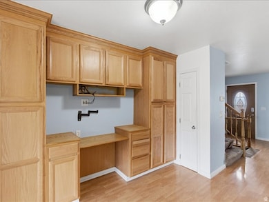 Unfurnished office with built in study area and light wood-type flooring