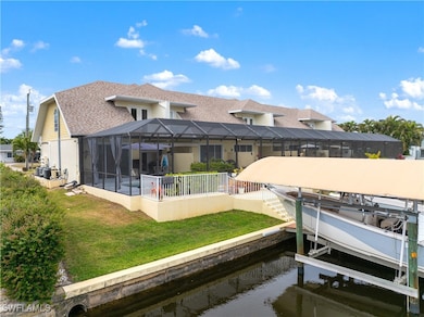 View of dock with a lanai, boat lift, and a yard