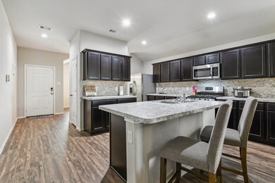 This photo showcases a modern kitchen with dark ca