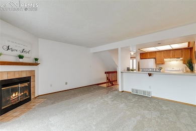 Unfurnished living room with a tiled fireplace, li