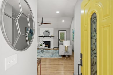Entryway featuring wood finished floors, ceiling fan, a fireplace, and recessed lighting