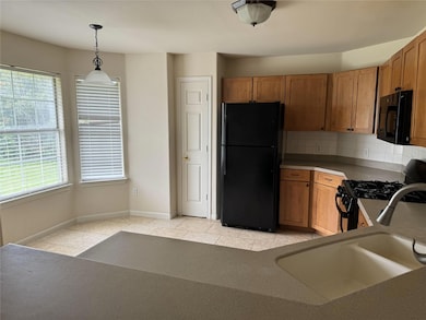 Kitchen with black appliances, hanging light fixt