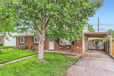View of front of house featuring brick siding, driveway, and an attached carport.