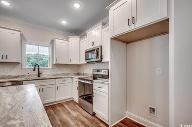 Kitchen featuring white cabinetry, a sink, light wood-type flooring, and appliances with stainless steel finishes