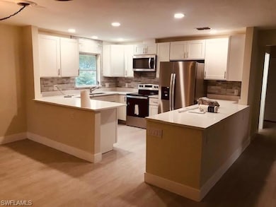 Kitchen featuring a peninsula, stainless steel appliances, light countertops, and recessed lighting
