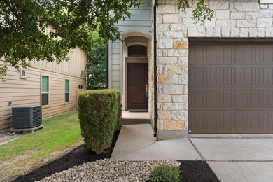 Property entrance with stone siding and a garage