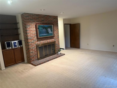Unfurnished living room with carpet flooring, a brick fireplace, and recessed lighting