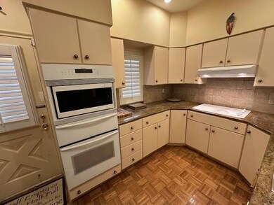 Kitchen with white cabinets, white appliances, and