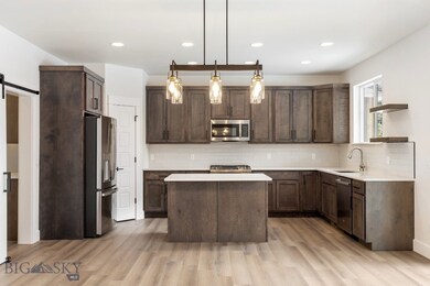 Kitchen with a barn door, light wood-type flooring