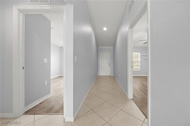 Corridor with light tile patterned floors, baseboa