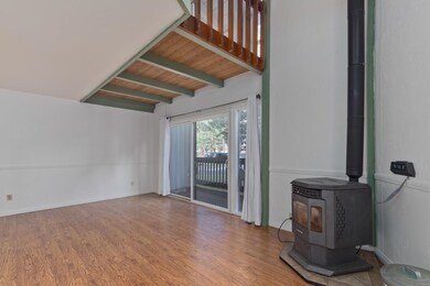 Unfurnished living room featuring a wood stove, a wooden ceiling with exposed beams, and wood finished floors