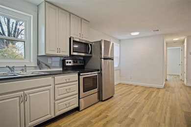 Kitchen featuring dark countertops, baseboards, ap