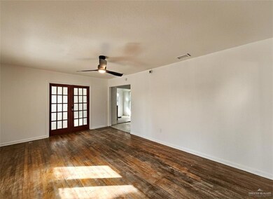 Spare room with dark wood-style floors, french doors, a ceiling fan, and a textured ceiling