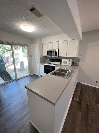 Kitchen featuring electric range, a textured ceil