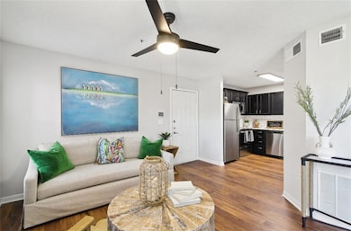 Living room featuring ceiling fan and hardwood / w