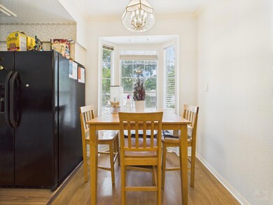 Dining room with wood finished floors, a chandeli