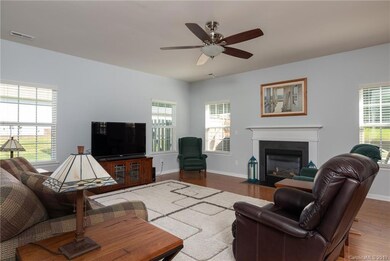 Bright living room with tons of windows, neutral paint, hardwoods and gas fireplace