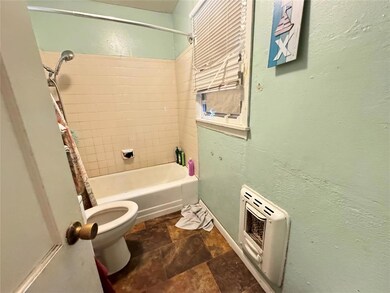 Bathroom featuring toilet, heating unit, and showe