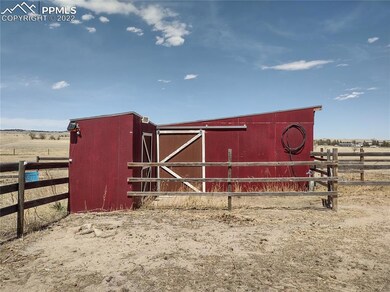 Side of barn has enclosed tack room on the left