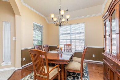 The formal dining room features wood flooring, chair railing and crown molding.