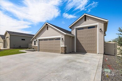 Ranch-style home featuring a garage, concrete driveway, stone siding, and a gate