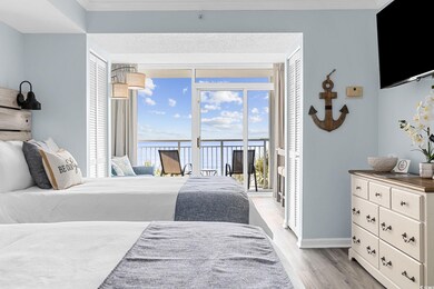 Bedroom with access to exterior, light wood finished floors, a water view, baseboards, and crown molding