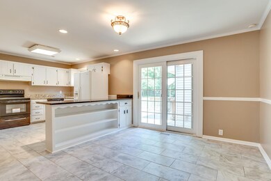 Large bright kitchen with new tile flooring, granite counters, new range and recently new dishwasher