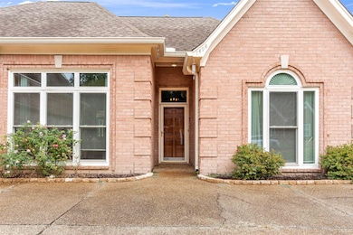 View of front of house with brick siding and a shingled roof