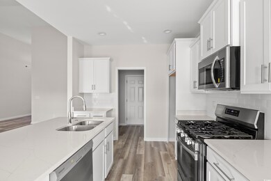 Kitchen with light stone countertops, stainless st