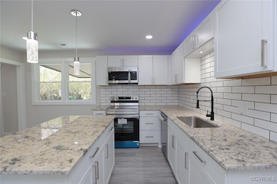 Kitchen with backsplash, a sink, white cabinetry,