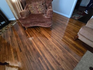 Sitting room with baseboards and wood finished flo