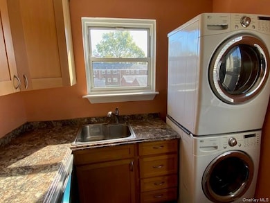 Laundry room with stacked washer / drying machine and cabinet space