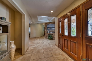 Foyer entrance featuring a textured ceiling and light stone finish floors