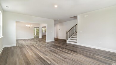 Empty room with baseboards, visible vents, wood fi