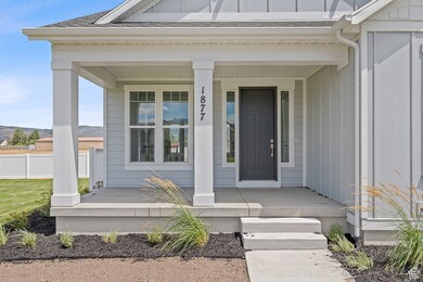 Doorway to property with a porch, a shingled roof, and board and batten siding