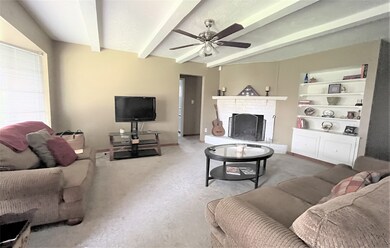 Spacious living area with wood-burning fireplace and custom shelving