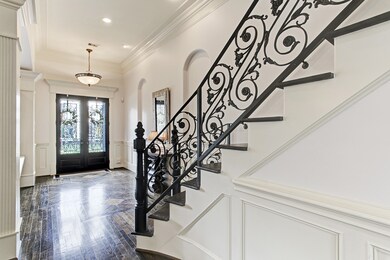 Grand Entry and Foyer with abundant natural light.  Beautifully detailed hardwood floors, iron work, and dramatic stairwell.