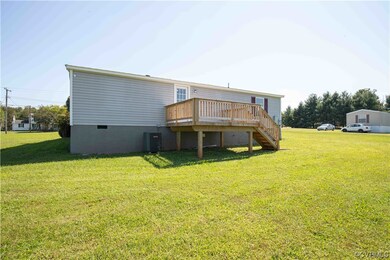 Back of house with central AC, a lawn, and a deck