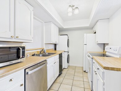 Kitchen featuring white cabinets, a raised ceiling